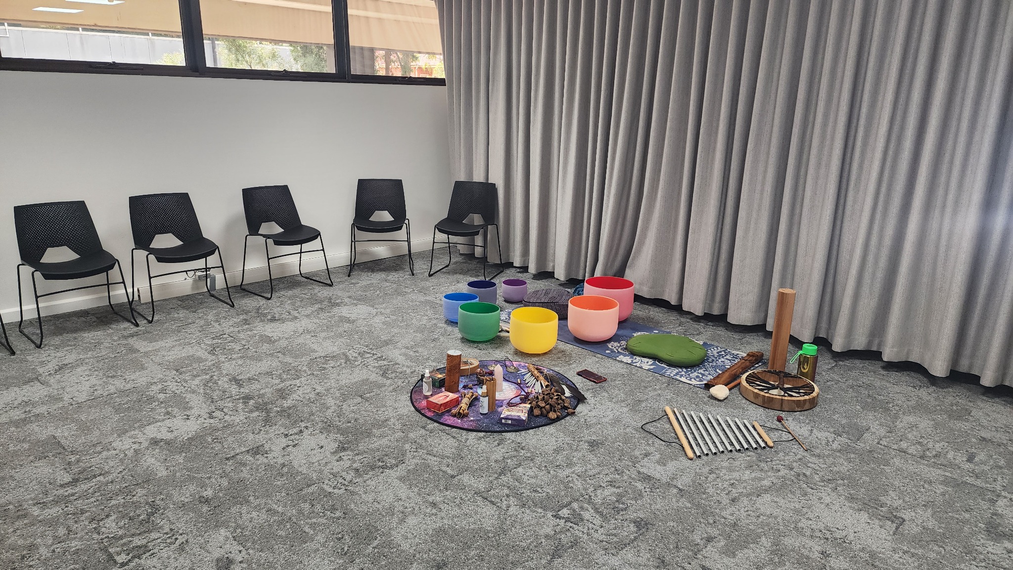 An empty corporate room prepared with chairs, sound bowls and instruments