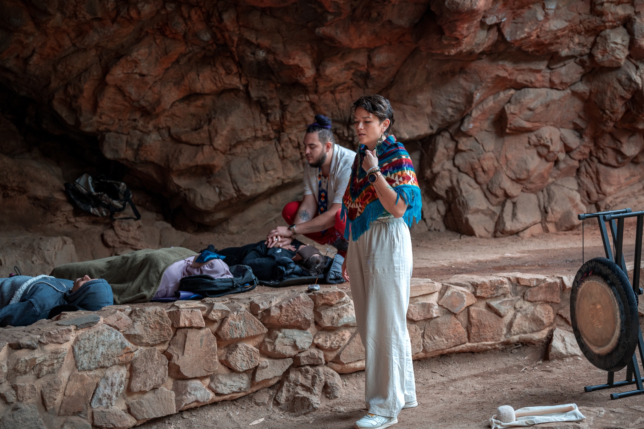 Facilitators guiding a group breathwork ceremony in a natural cave setting