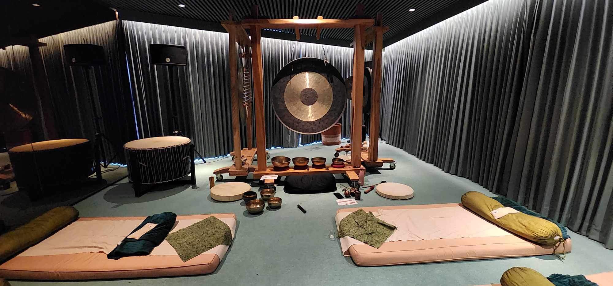 A sound immersion room prepared with gongs, drums and floor mats